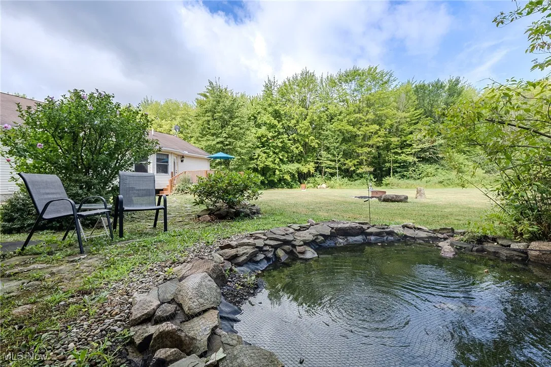 View of green lawn featuring a KOI Pond