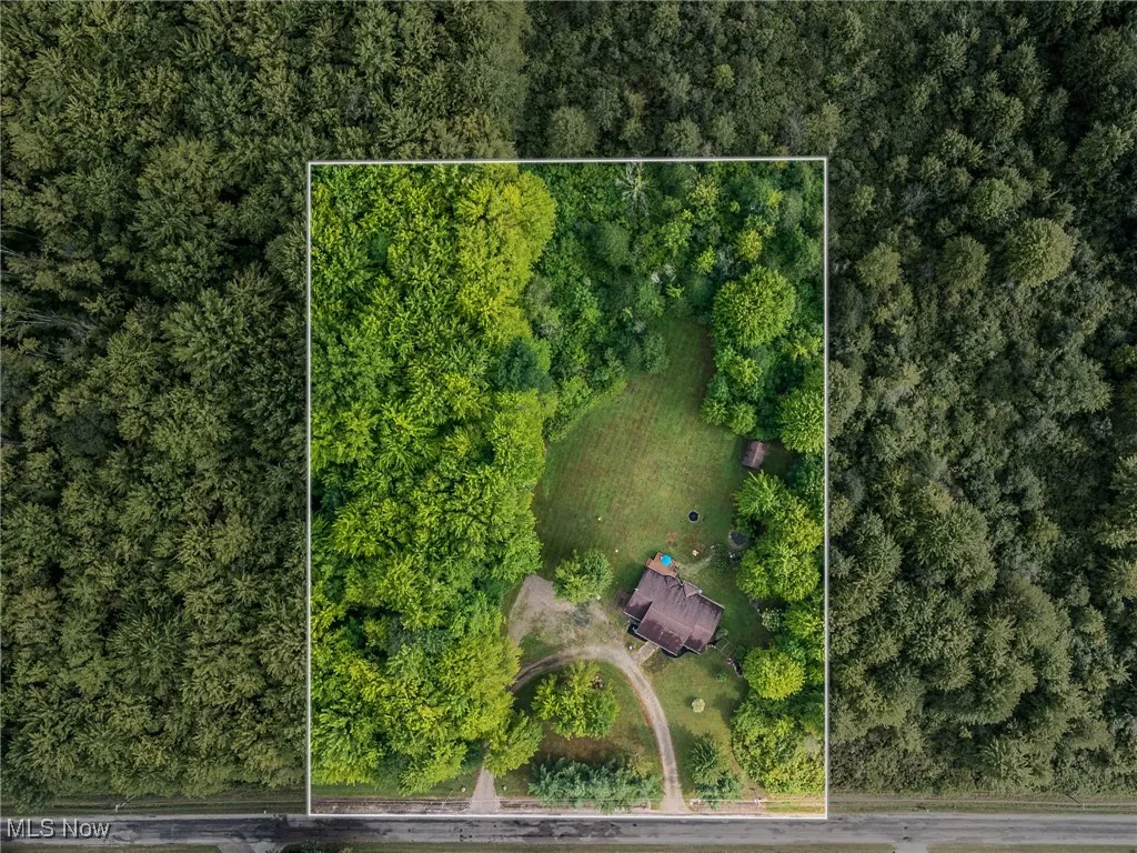 Aerial view of property's location with property boundaries highlighted and a heavily wooded area