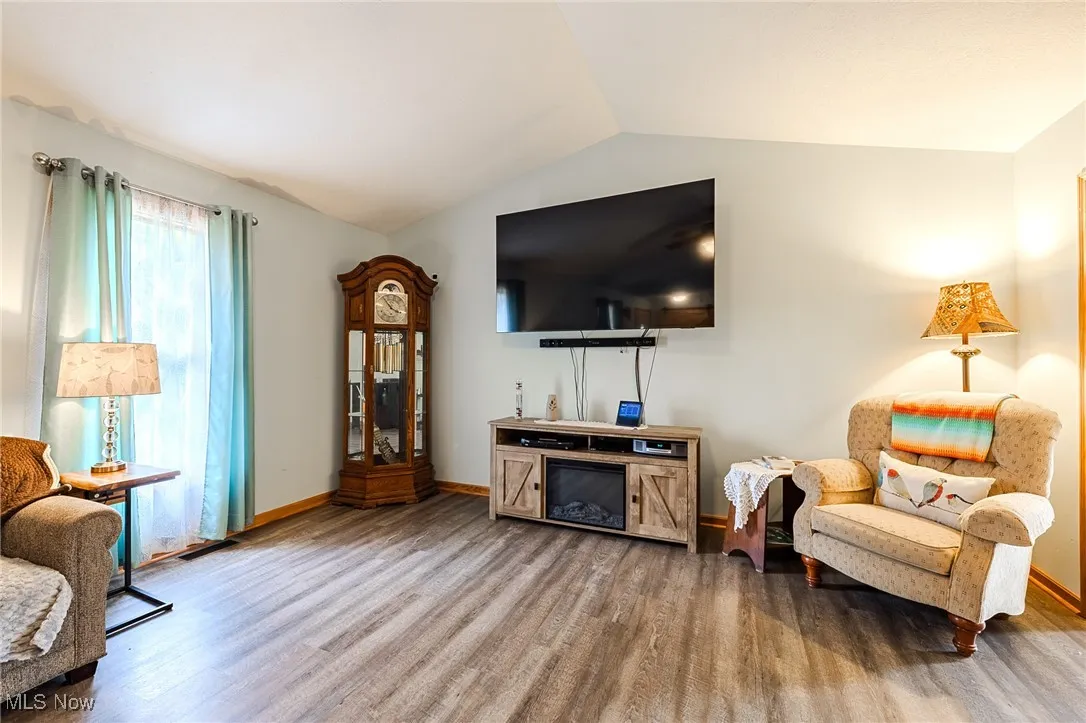 Living area with wood finished floors and lofted ceiling