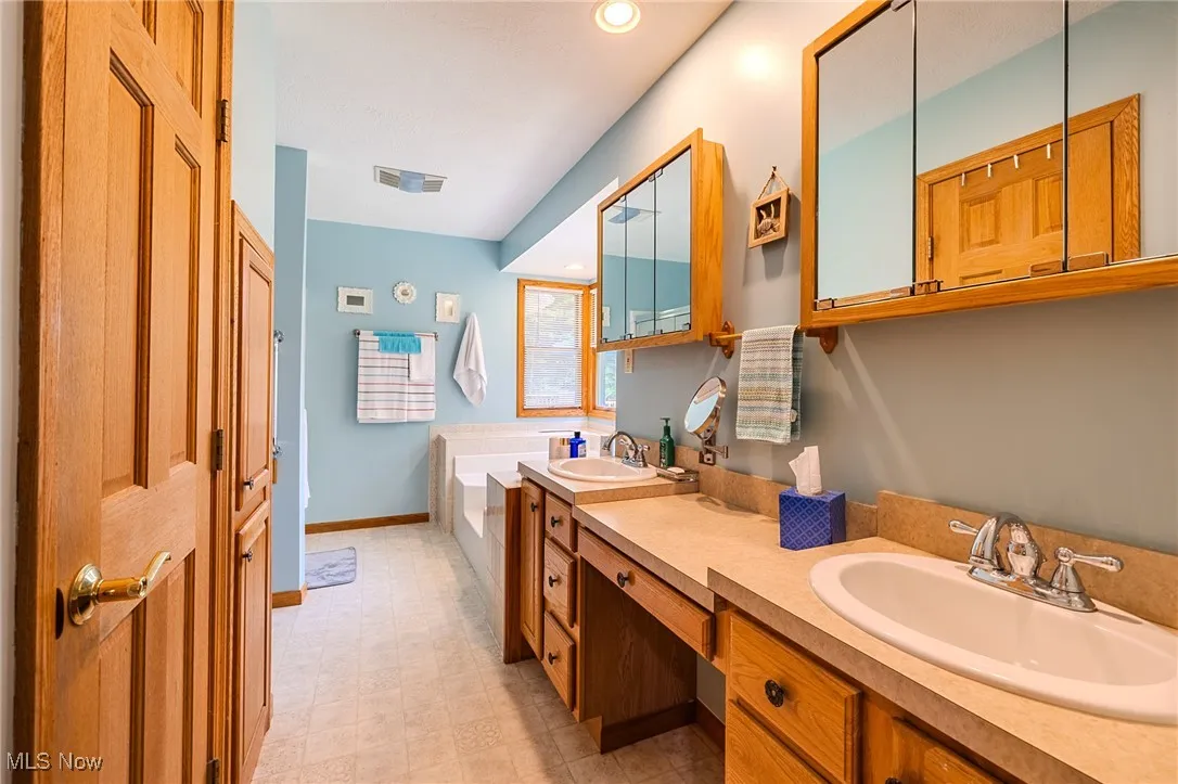 Bathroom featuring double vanity, recessed lighting, a garden tub, and tile patterned floors