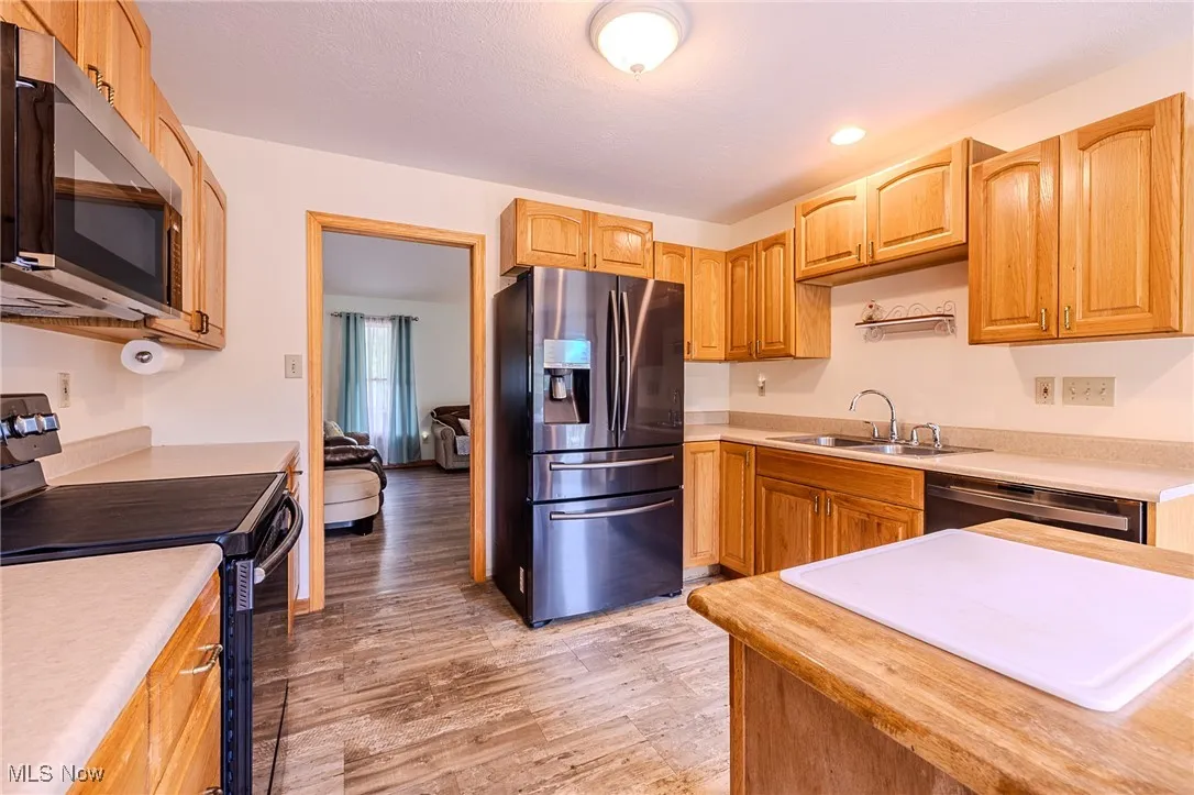 Kitchen with stainless steel appliances, light wood finished floors, light countertops, and recessed lighting