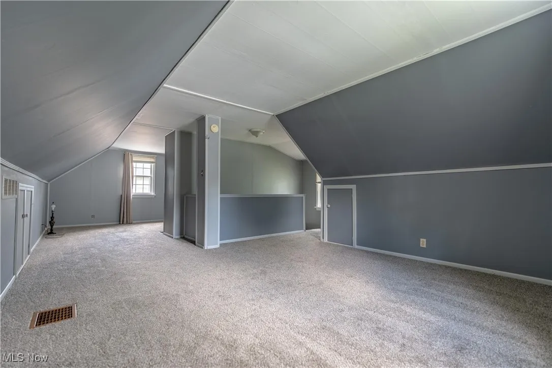 Bonus room featuring carpet flooring and vaulted ceiling