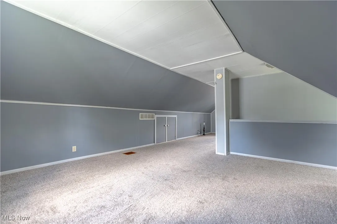 Bonus room featuring carpet flooring and lofted ceiling