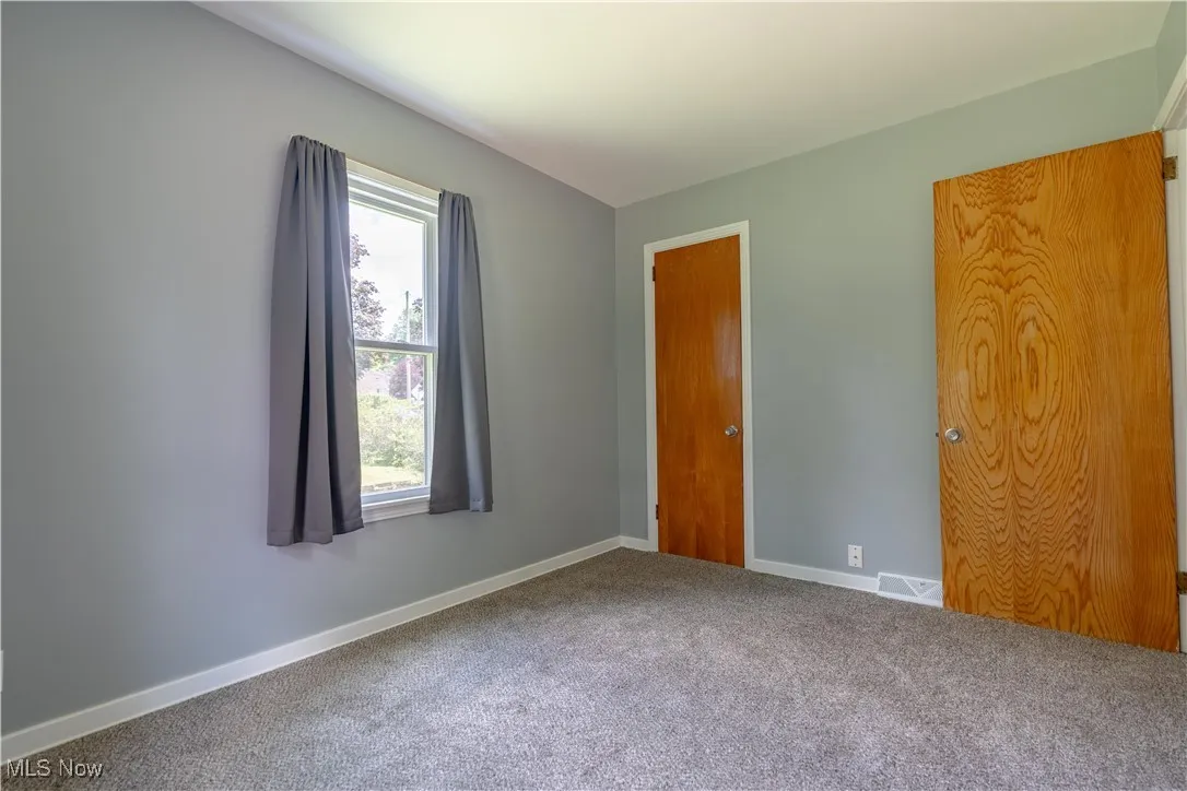 Unfurnished bedroom with carpet and baseboards