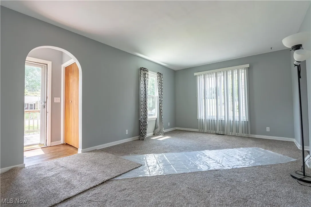 Spare room with arched walkways and carpet flooring