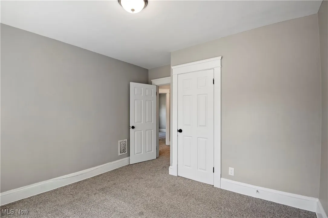Unfurnished bedroom with carpet floors and baseboards