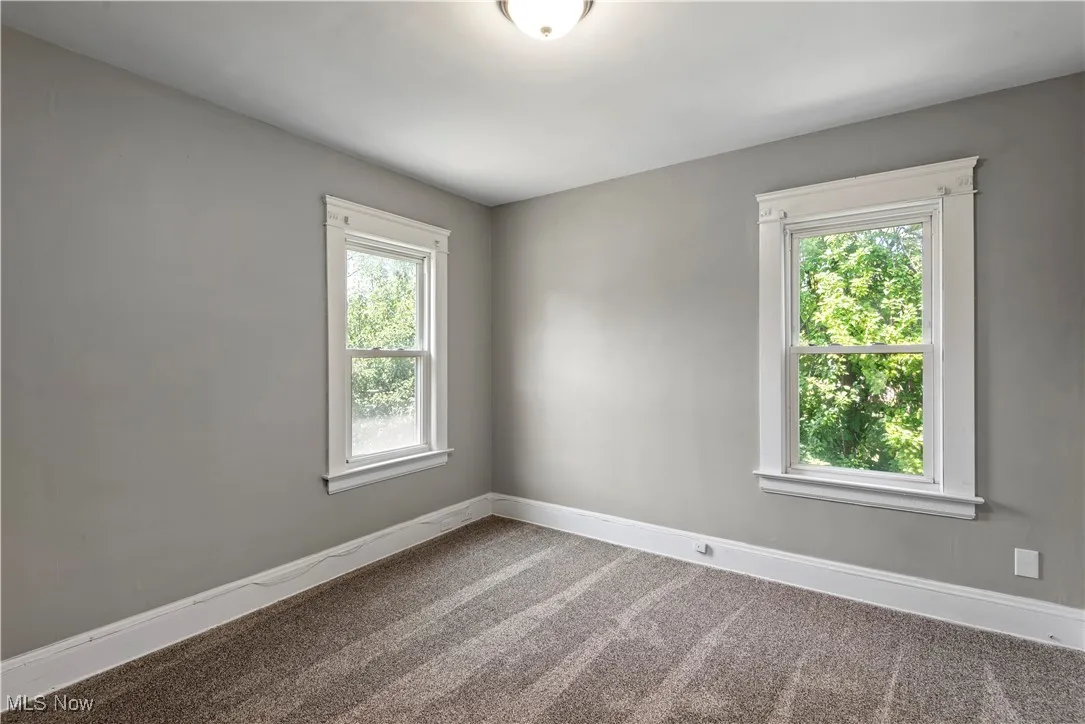 Empty room featuring baseboards and carpet flooring