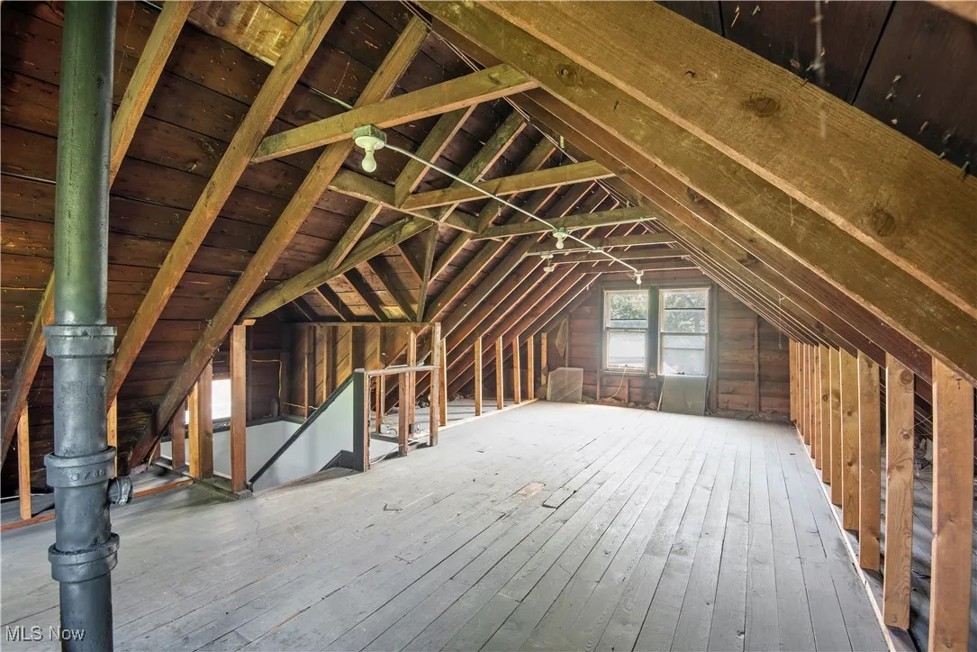 Unfinished attic with an upstairs landing