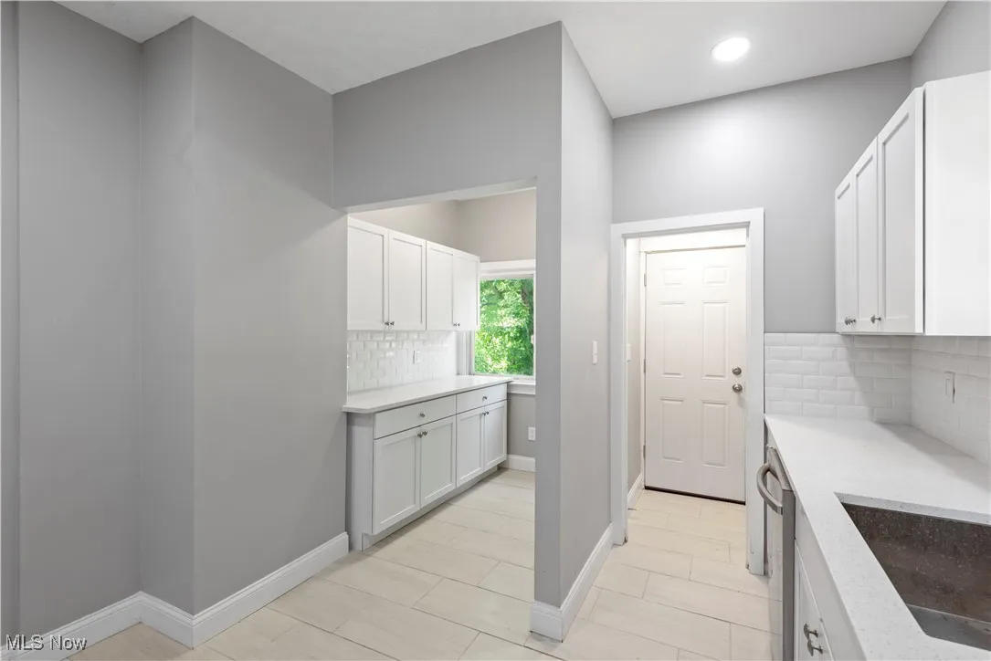 Laundry area featuring baseboards and recessed lighting