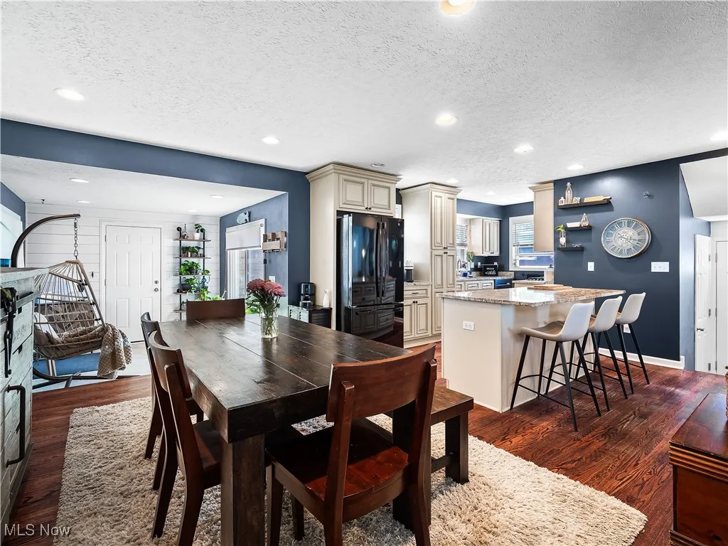Dining room with dark hardwood flooring open to kitchen and family room