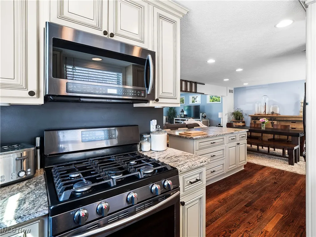 Kitchen featuring hardwood flooring, granite counters, and cream colored cabinets