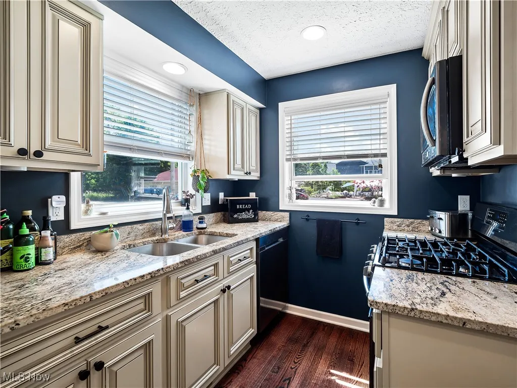 Kitchen featuring hardwood flooring, granite counters, and cream colored cabinets