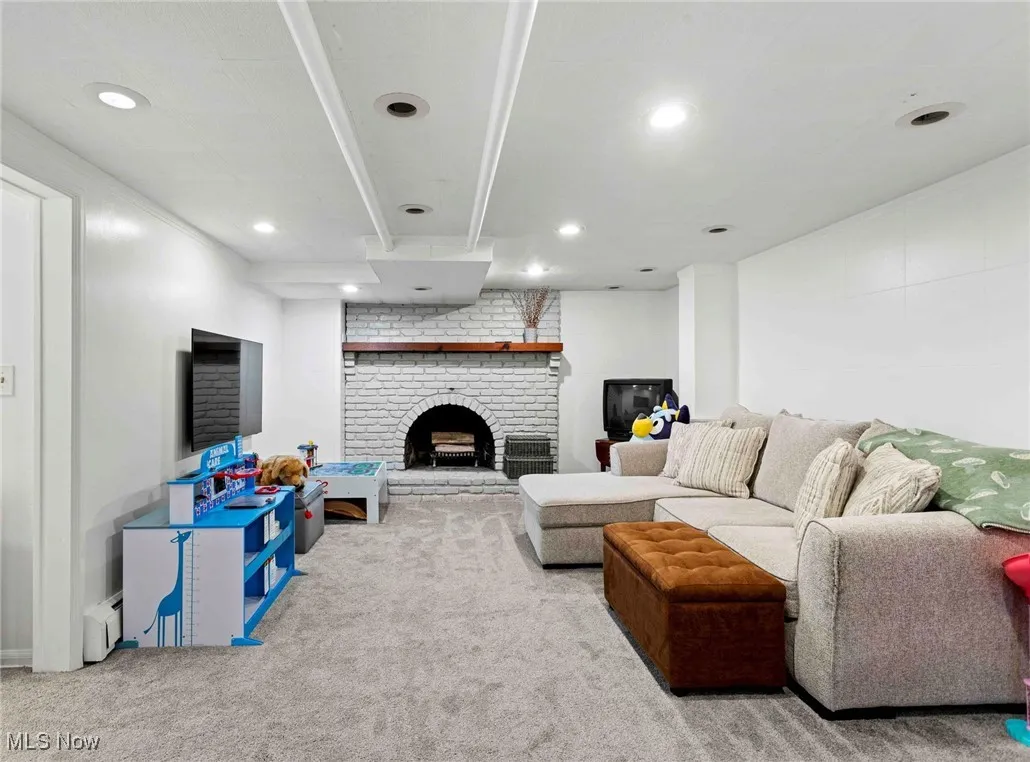 Carpeted living room with a fireplace, recessed lighting, and a baseboard radiator