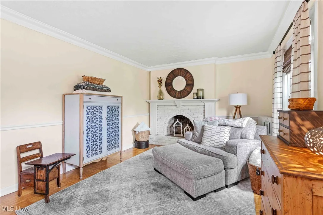 Living area featuring ornamental molding and a fireplace