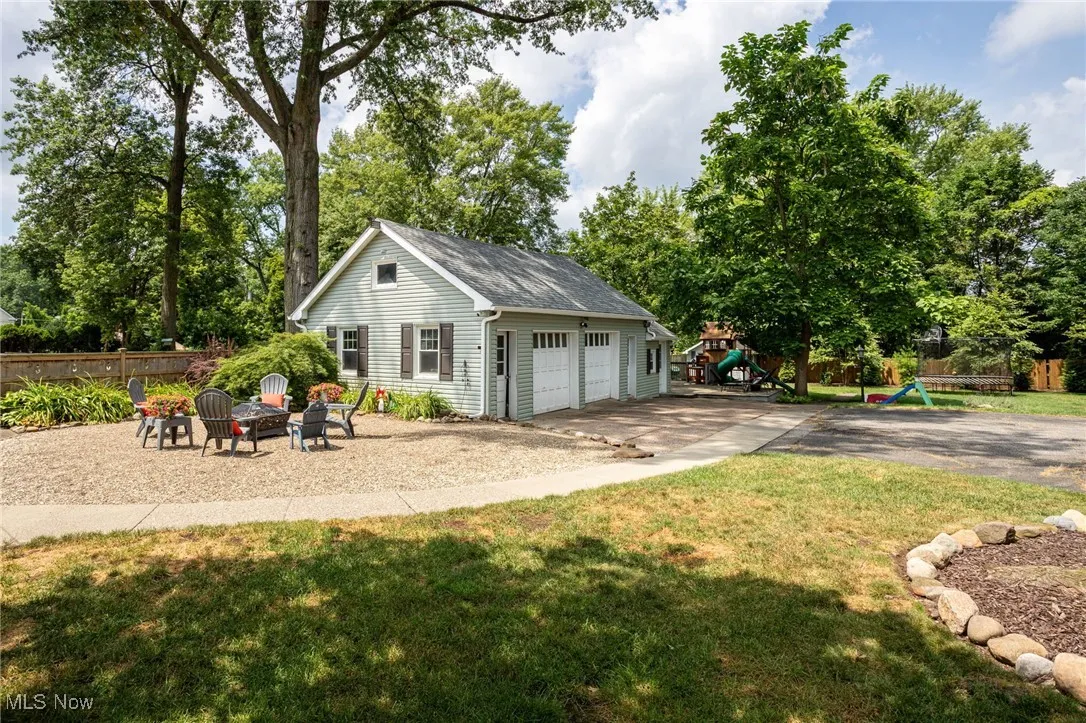 Detached garage featuring view of wooded area