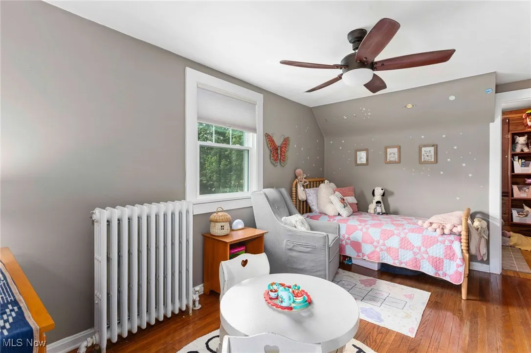 Bedroom with radiator, hardwood / wood-style floors, and a ceiling fan