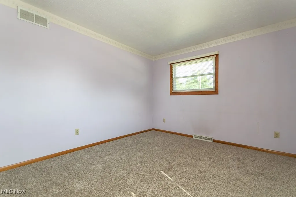 Unfurnished room with carpet flooring and a textured ceiling
