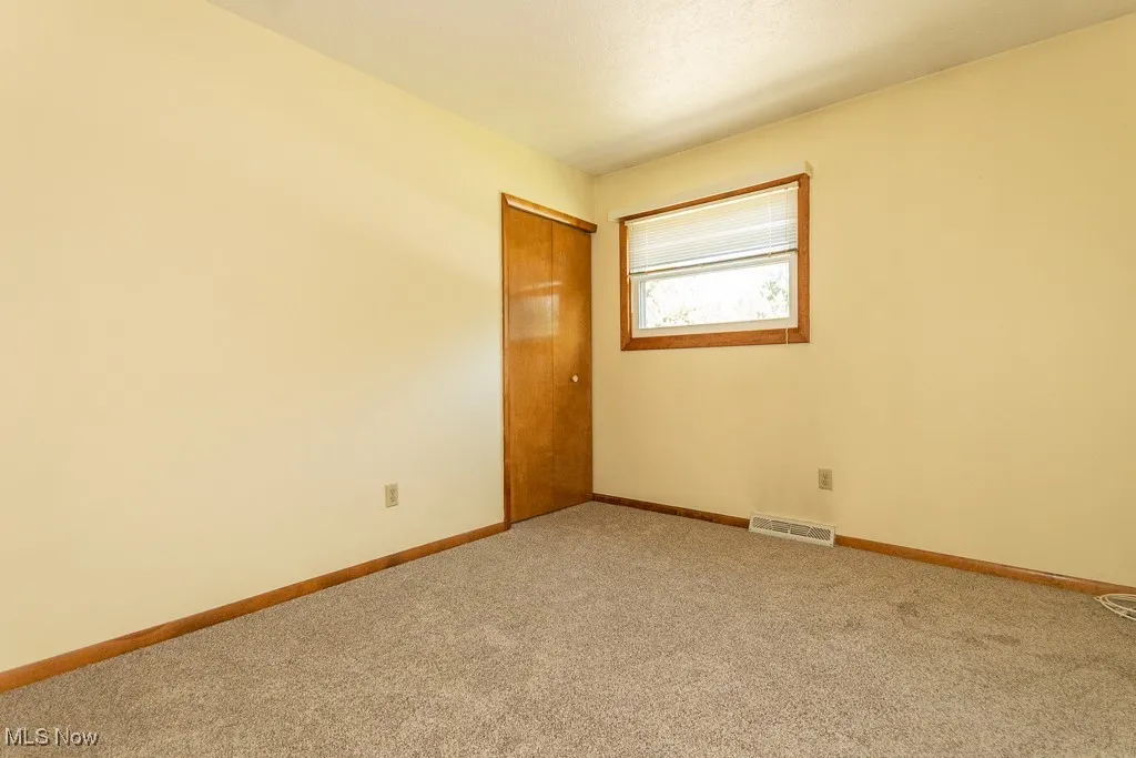 Empty room featuring carpet floors and baseboards