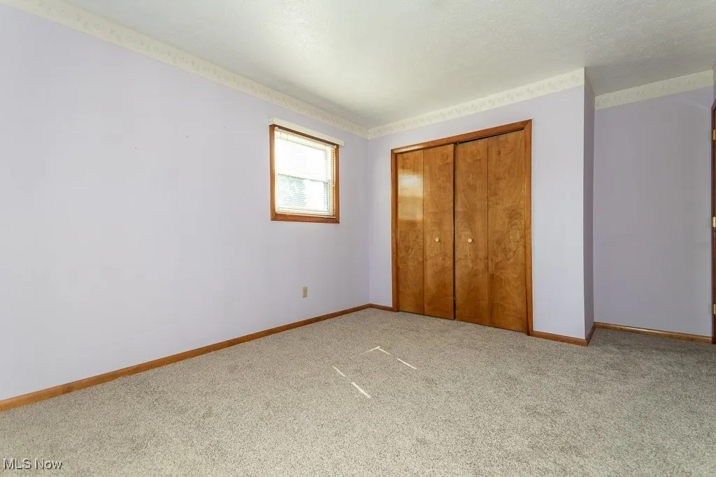 Unfurnished bedroom featuring carpet flooring, a closet, and a textured ceiling