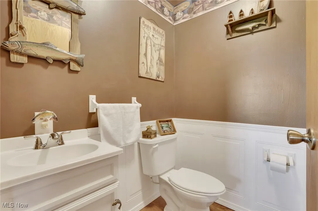 Bathroom featuring a wainscoted wall, a decorative wall, and vanity
