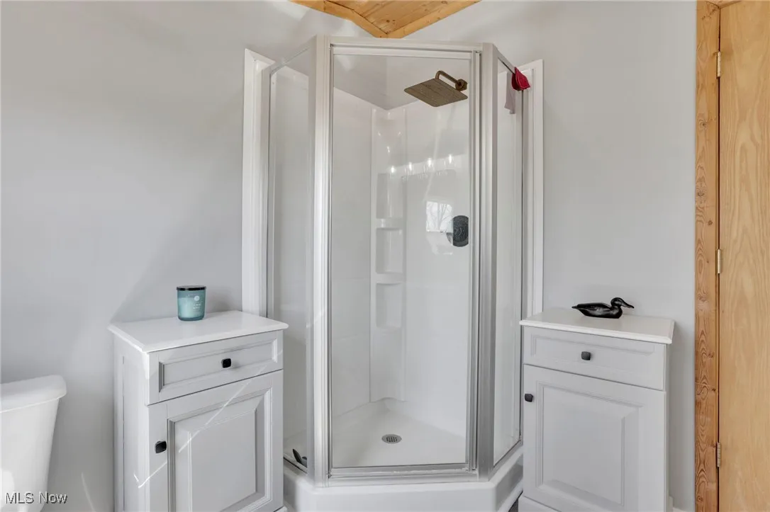Full bath with toilet and a shower stall