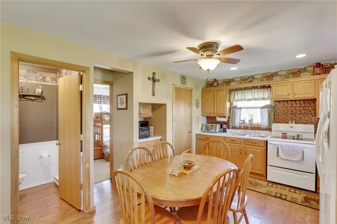 Kitchen featuring white appliances, light wood-type flooring, light countertops, a ceiling fan, and recessed lighting