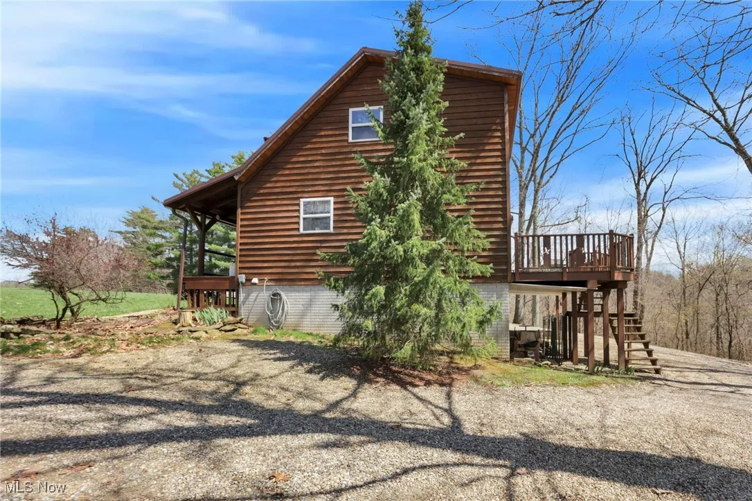 View of property exterior featuring stairway and a deck