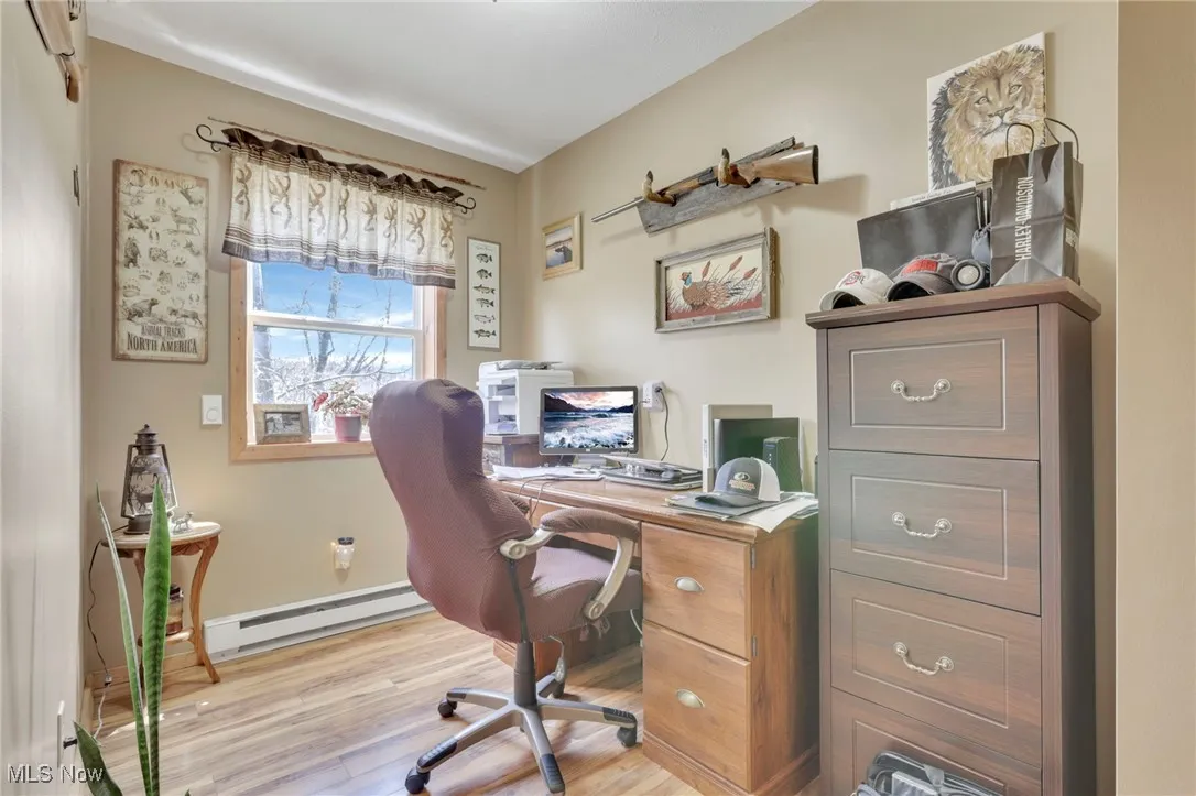 Office area with a baseboard radiator and wood finished floors