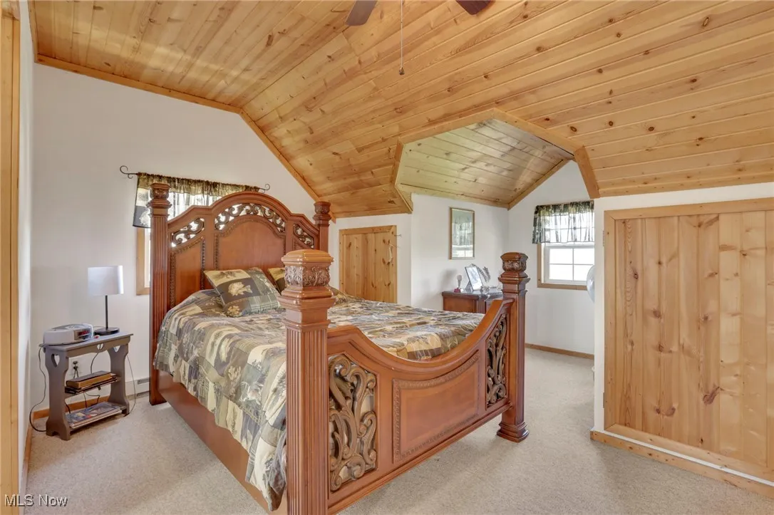 Bedroom with wooden ceiling, carpet floors, and lofted ceiling