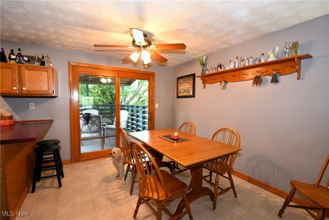 Dining area with a textured ceiling, a ceiling fan, and light flooring
