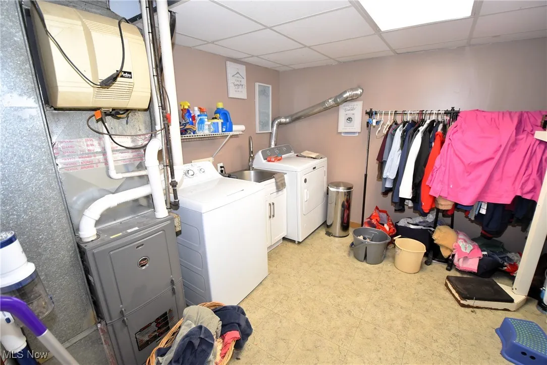 Washroom featuring washer and dryer, heating unit, and light floors
