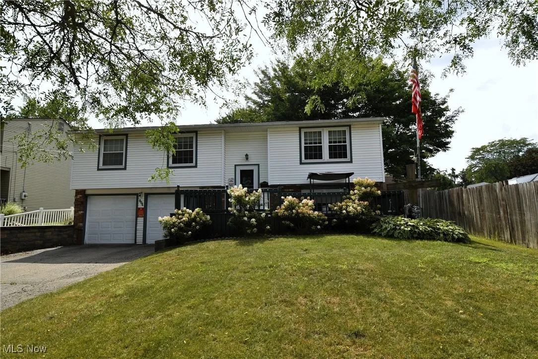 Split foyer home with asphalt driveway, an attached garage, and brick siding