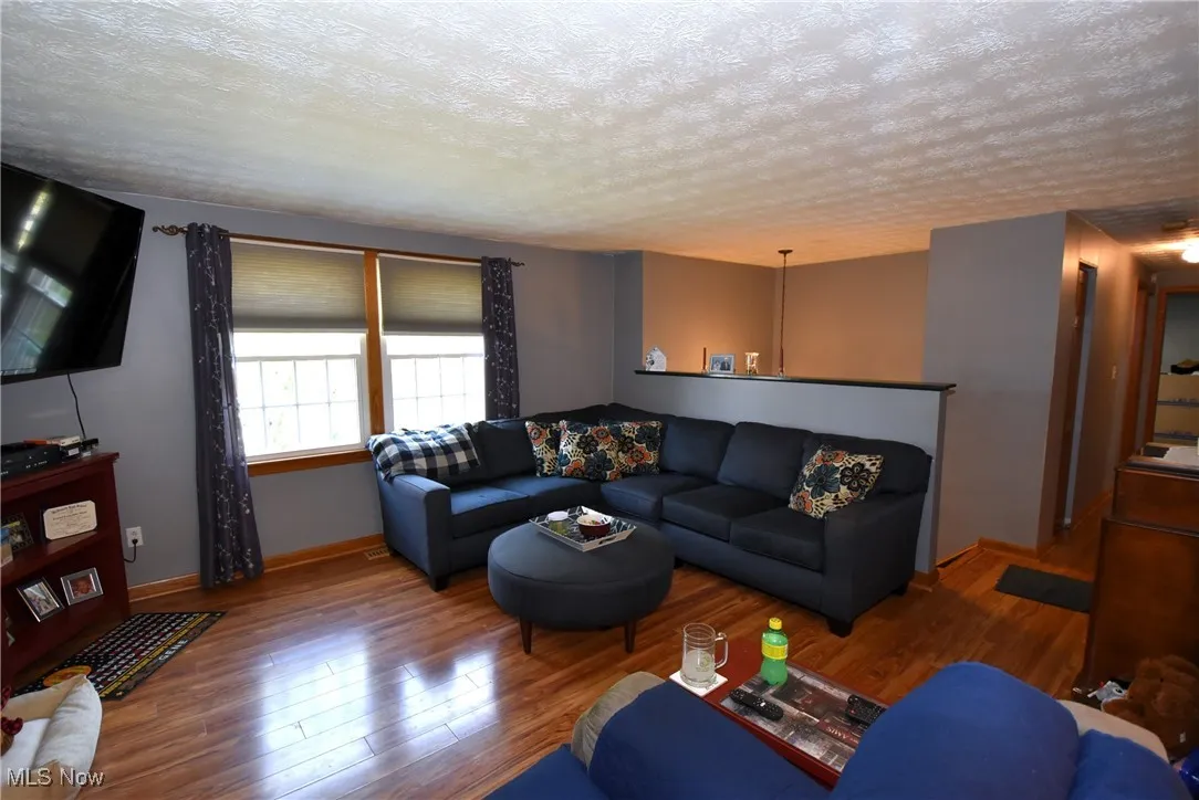 Living area with a textured ceiling and wood finished floors