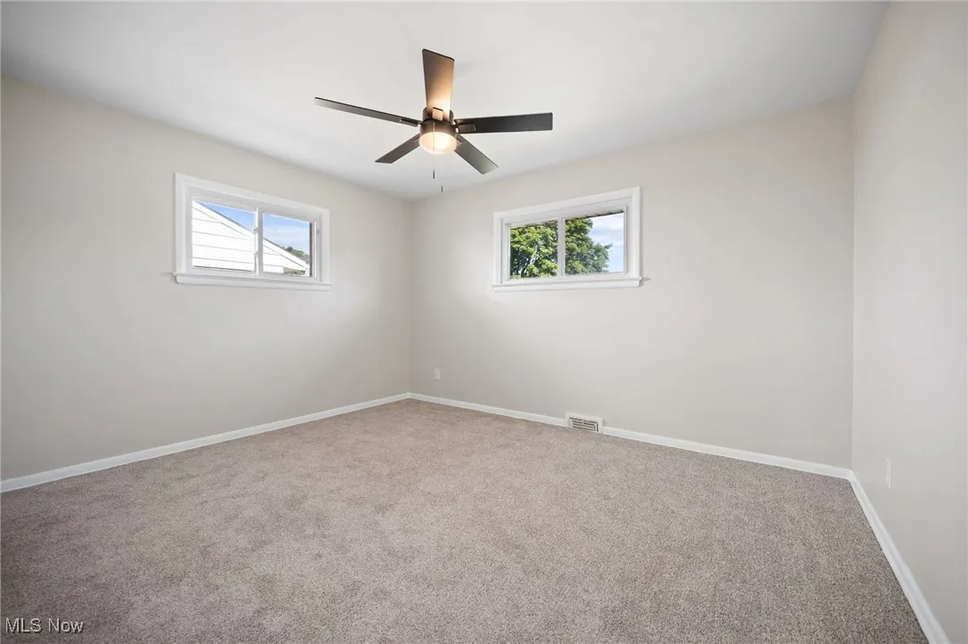 Empty room with carpet and ceiling fan
