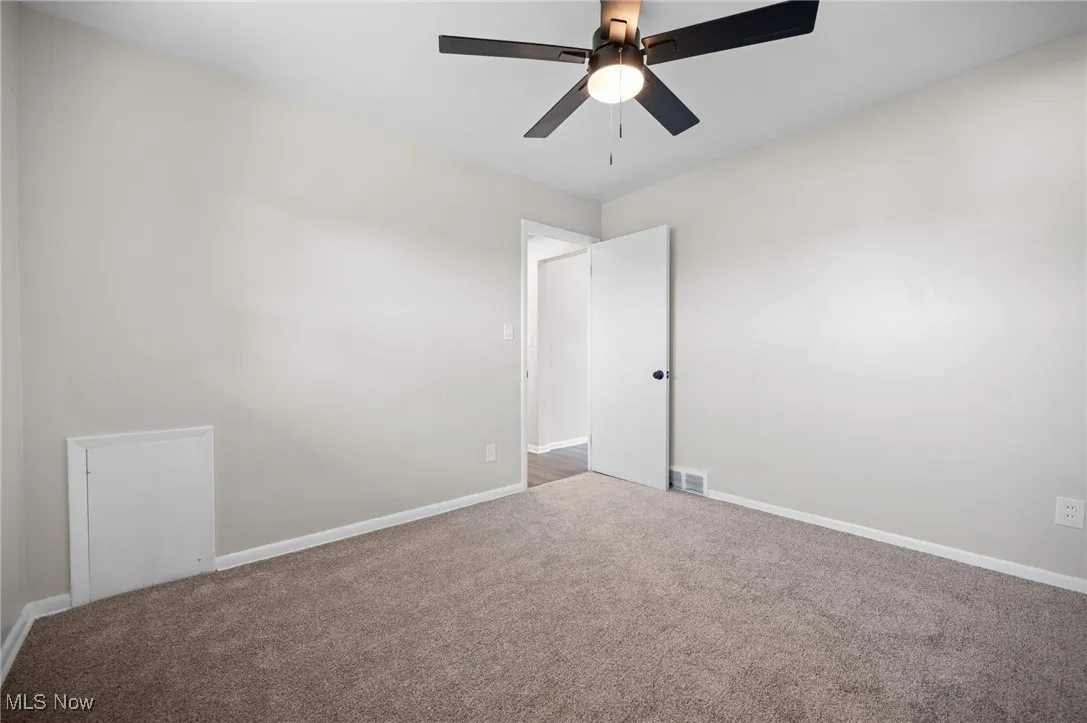 Carpeted empty room with a ceiling fan