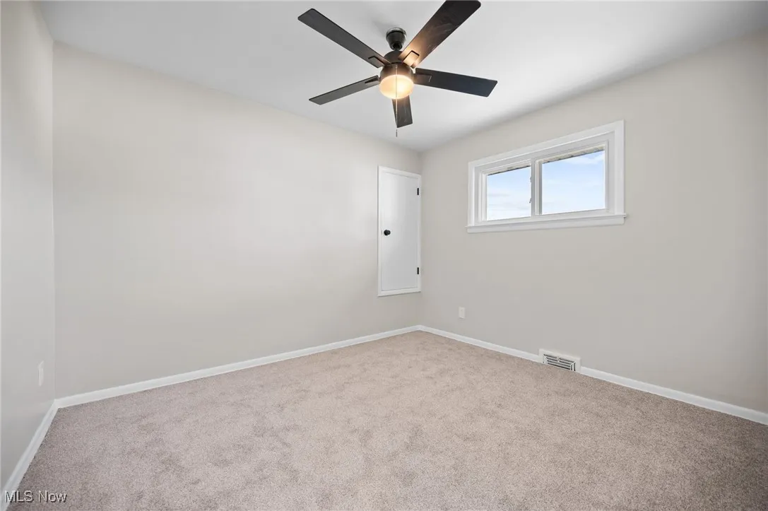 Carpeted empty room with a ceiling fan