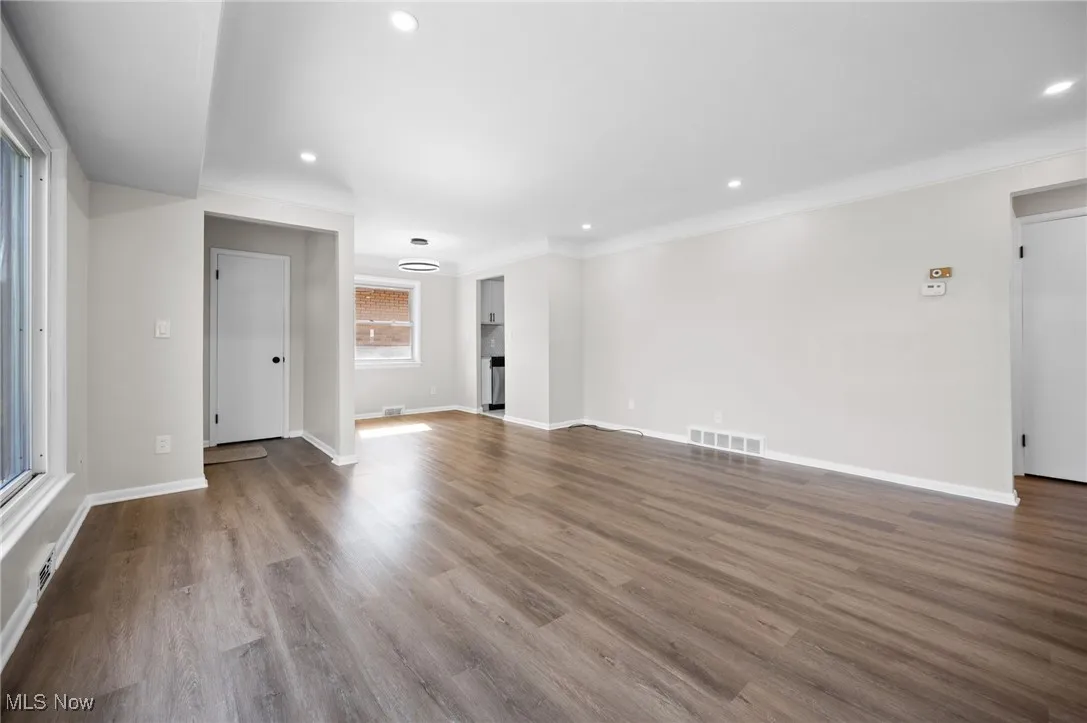 living room with wood finished floors, recessed lighting, and ornamental molding