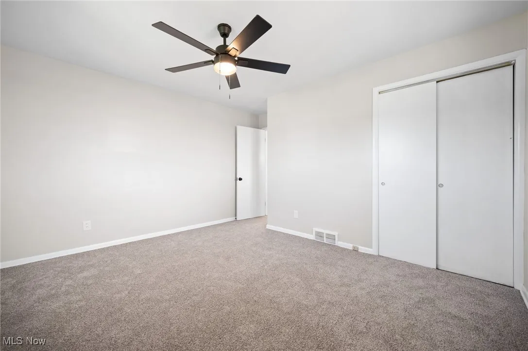 bedroom with carpet, a closet, and a ceiling fan