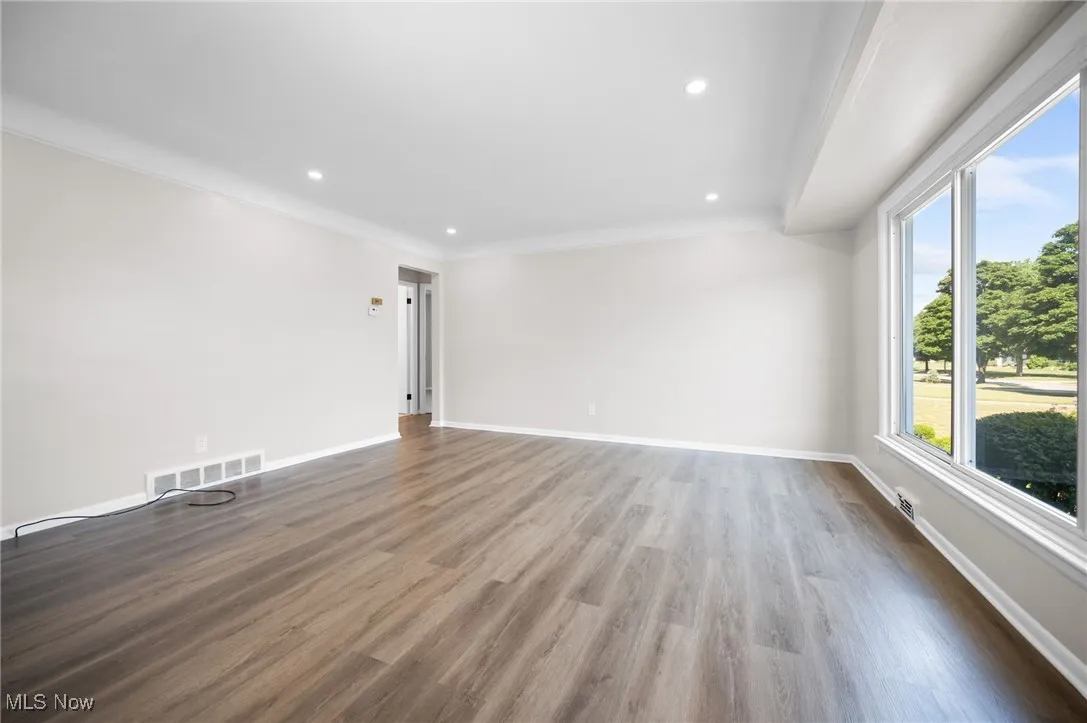 Living room featuring wood finished floors, recessed lighting, and crown molding