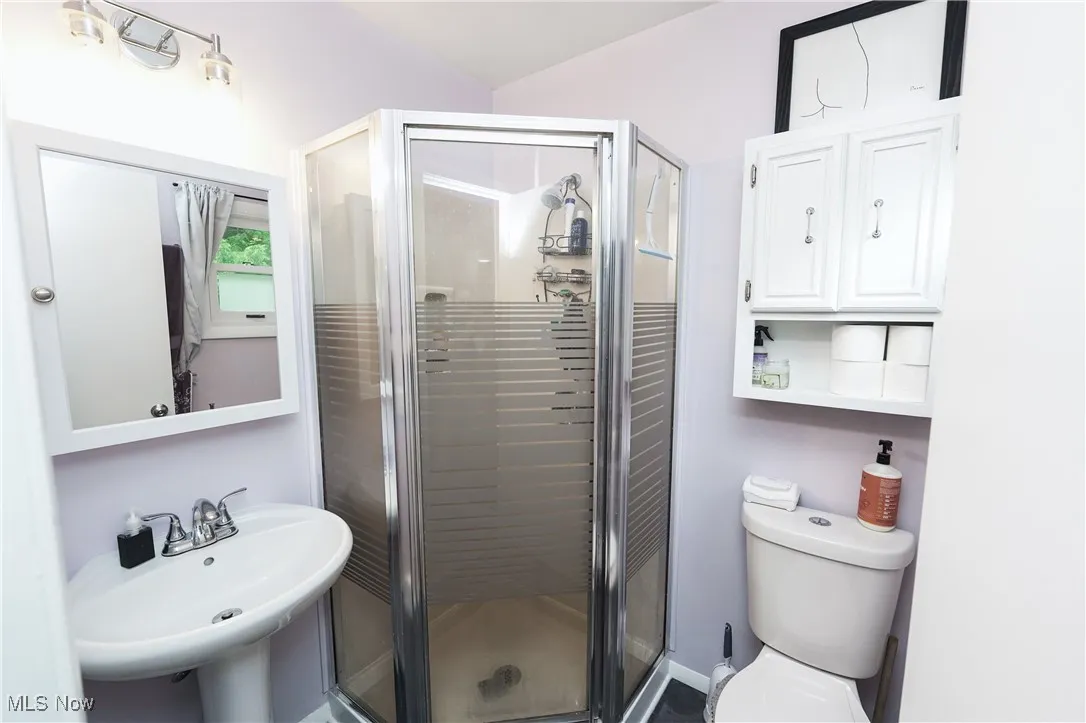 Bathroom featuring toilet and a shower stall