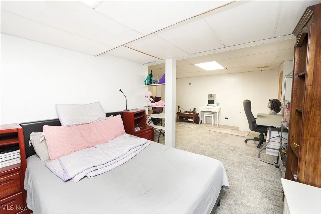Bedroom featuring a drop ceiling, a desk, and carpet floors