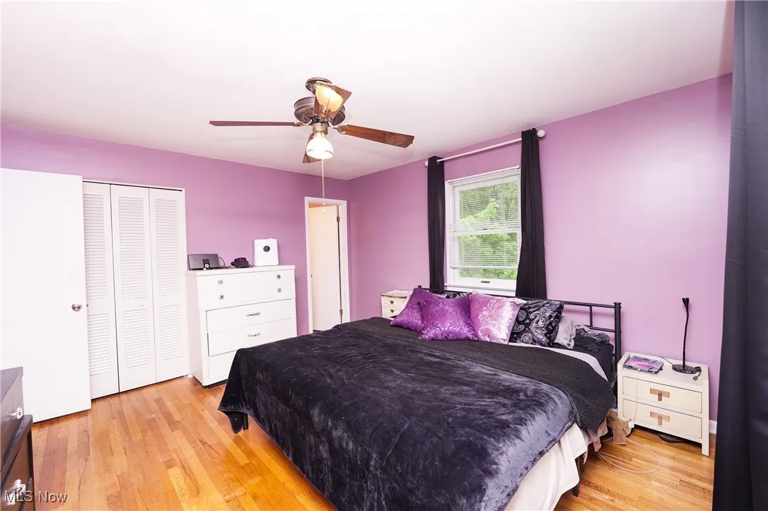 Bedroom with light wood finished floors, a closet, and a ceiling fan