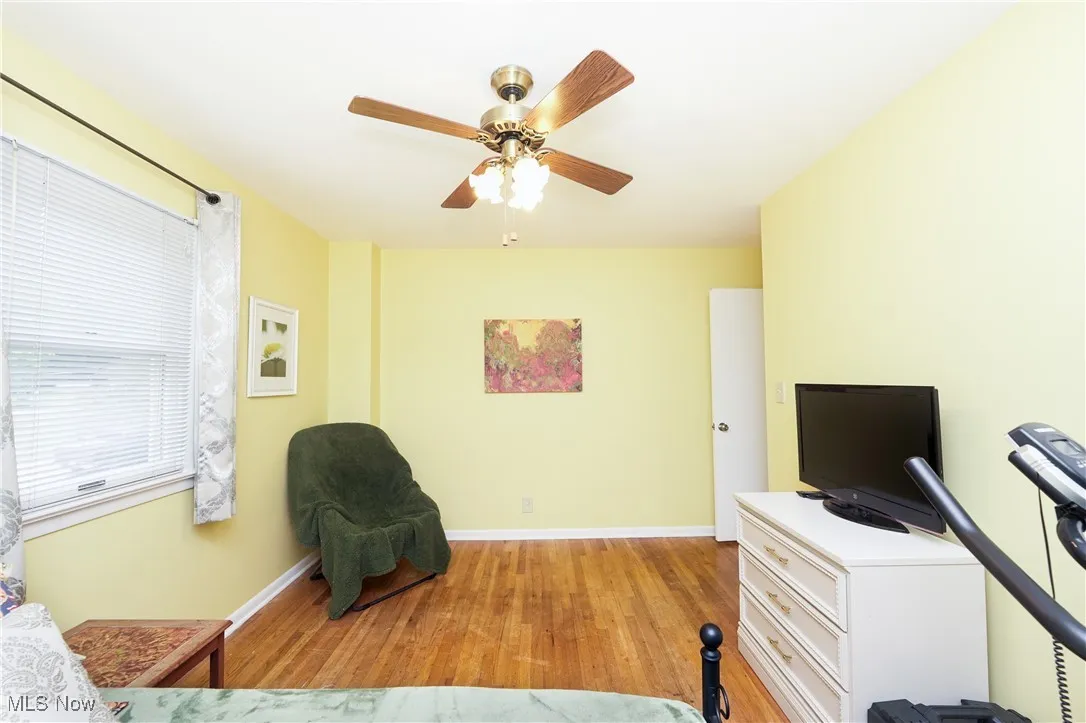 Sitting room with light wood-type flooring and a ceiling fan