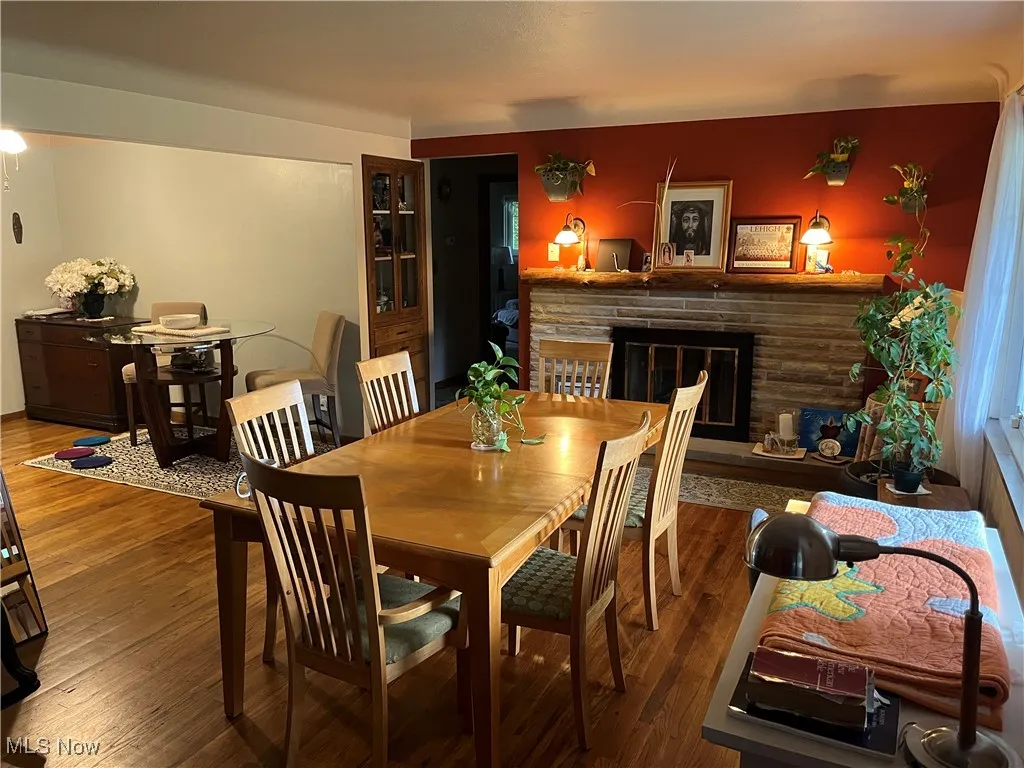 Dining area with a fireplace and wood finished floors