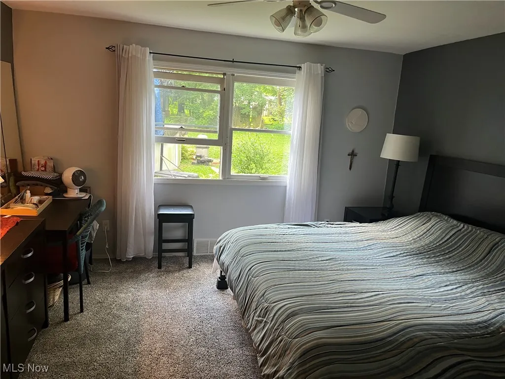 Carpeted bedroom with baseboards and ceiling fan