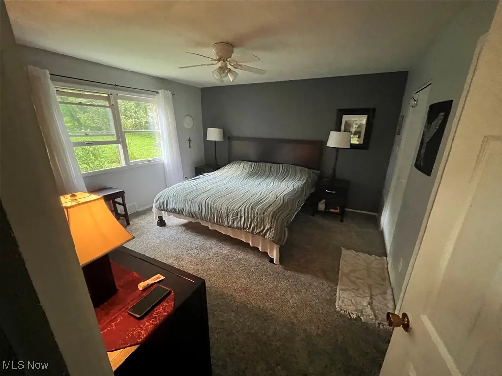 Carpeted bedroom featuring baseboards and a ceiling fan