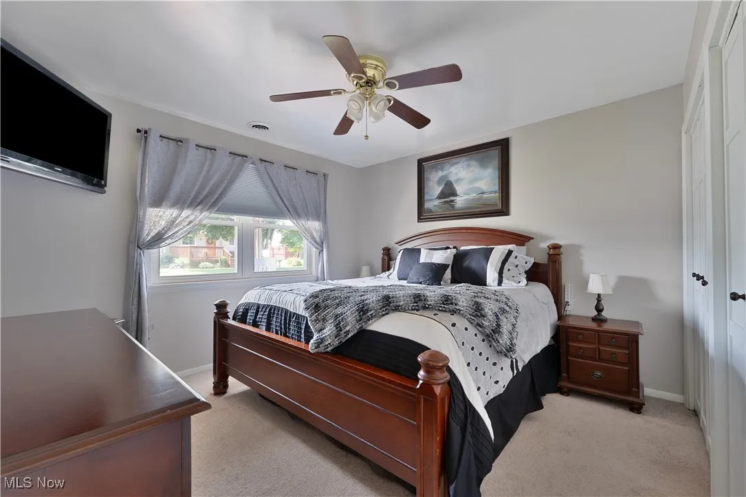 Bedroom with light colored carpet and ceiling fan