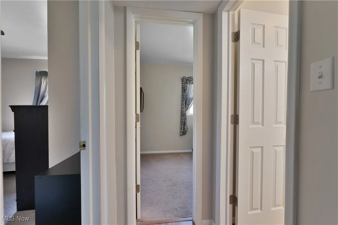 Corridor with carpet flooring and baseboards