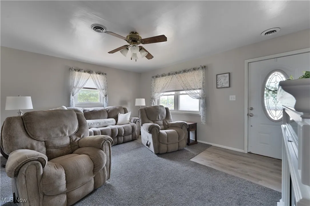 Living room featuring a ceiling fan and carpet flooring