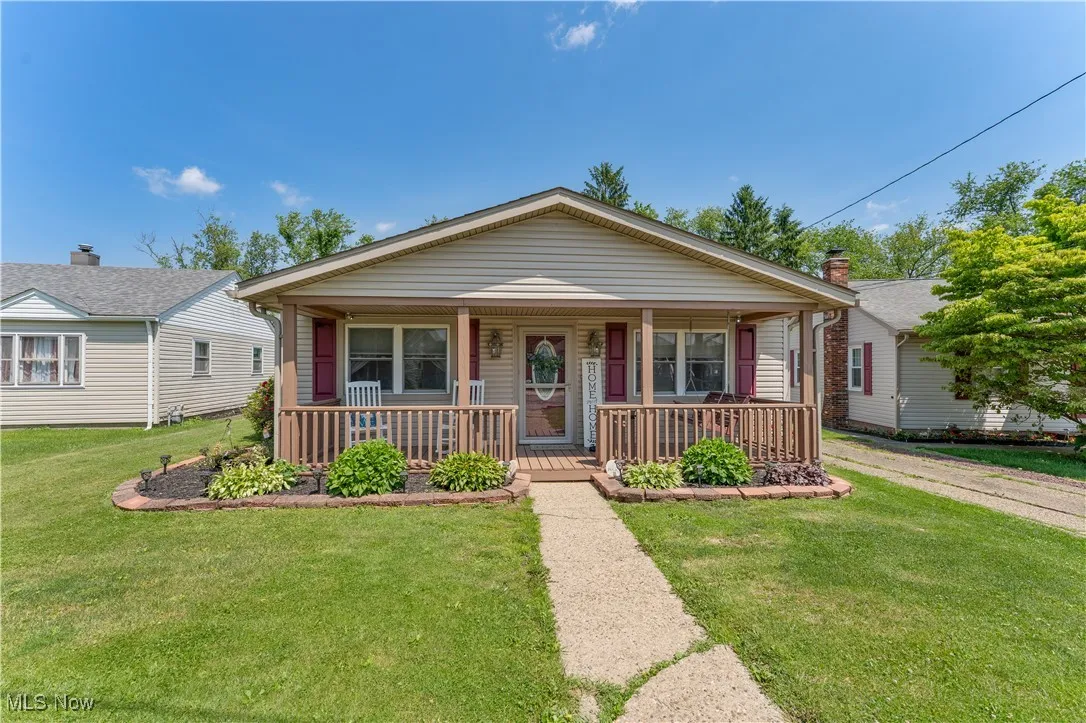 View of front of house featuring a front lawn and covered porch